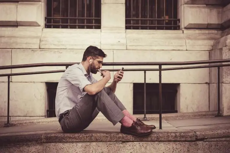 A man is walking outside with a smartphone